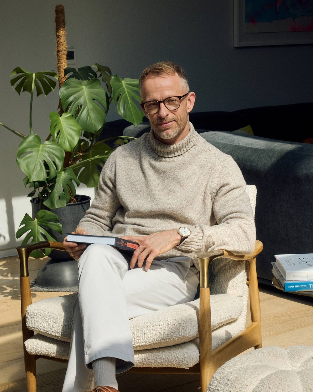 Gavin Cooper reading in an armchair, Bristol, 2026